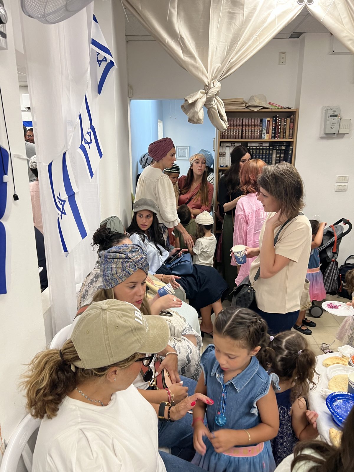 Côté femmes de la soirée d’accueil : discussions et enfants sous les drapeaux