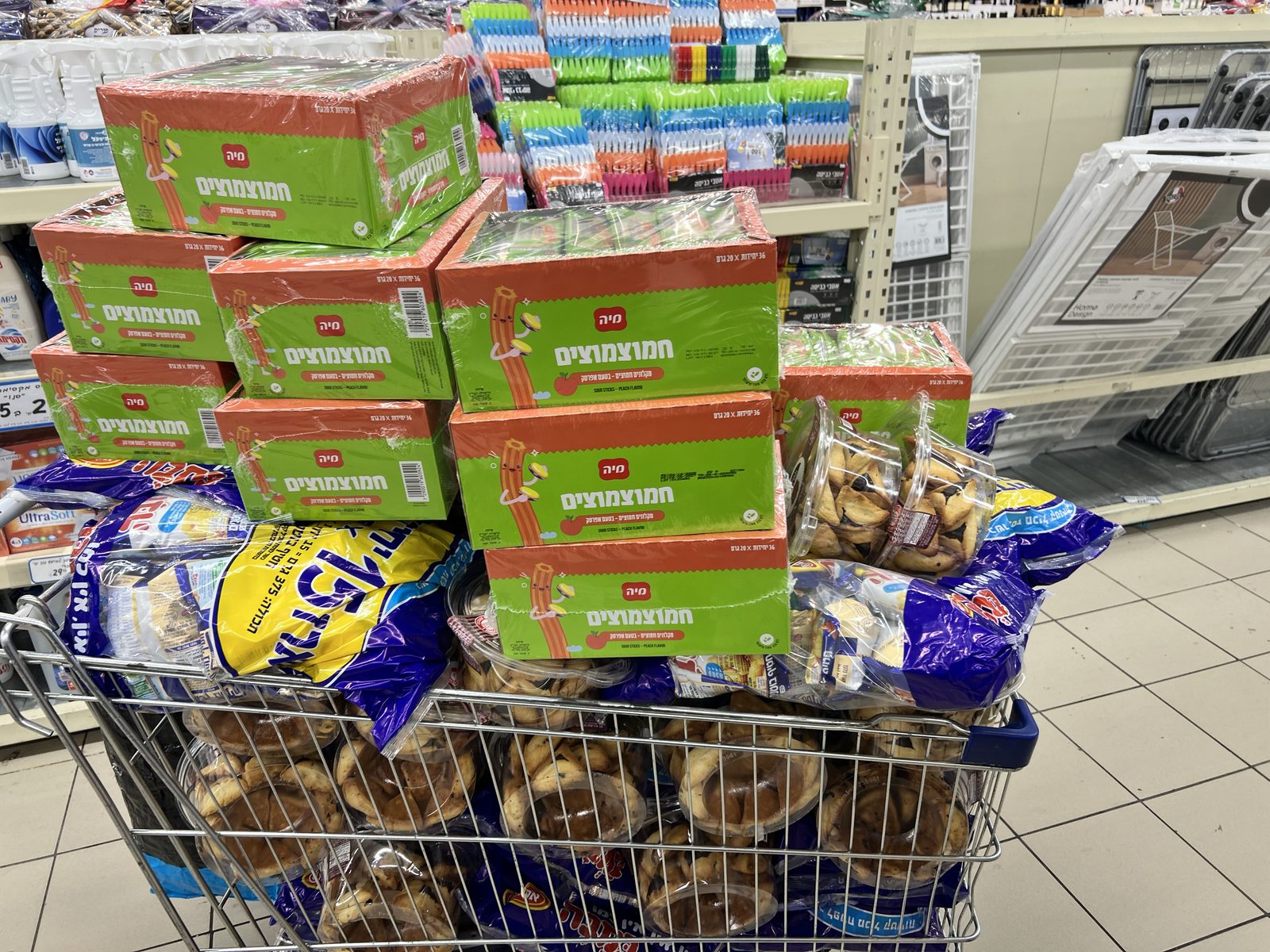 Caddie rempli de boîtes et de bretzels en magasin pour la collecte de Pourim