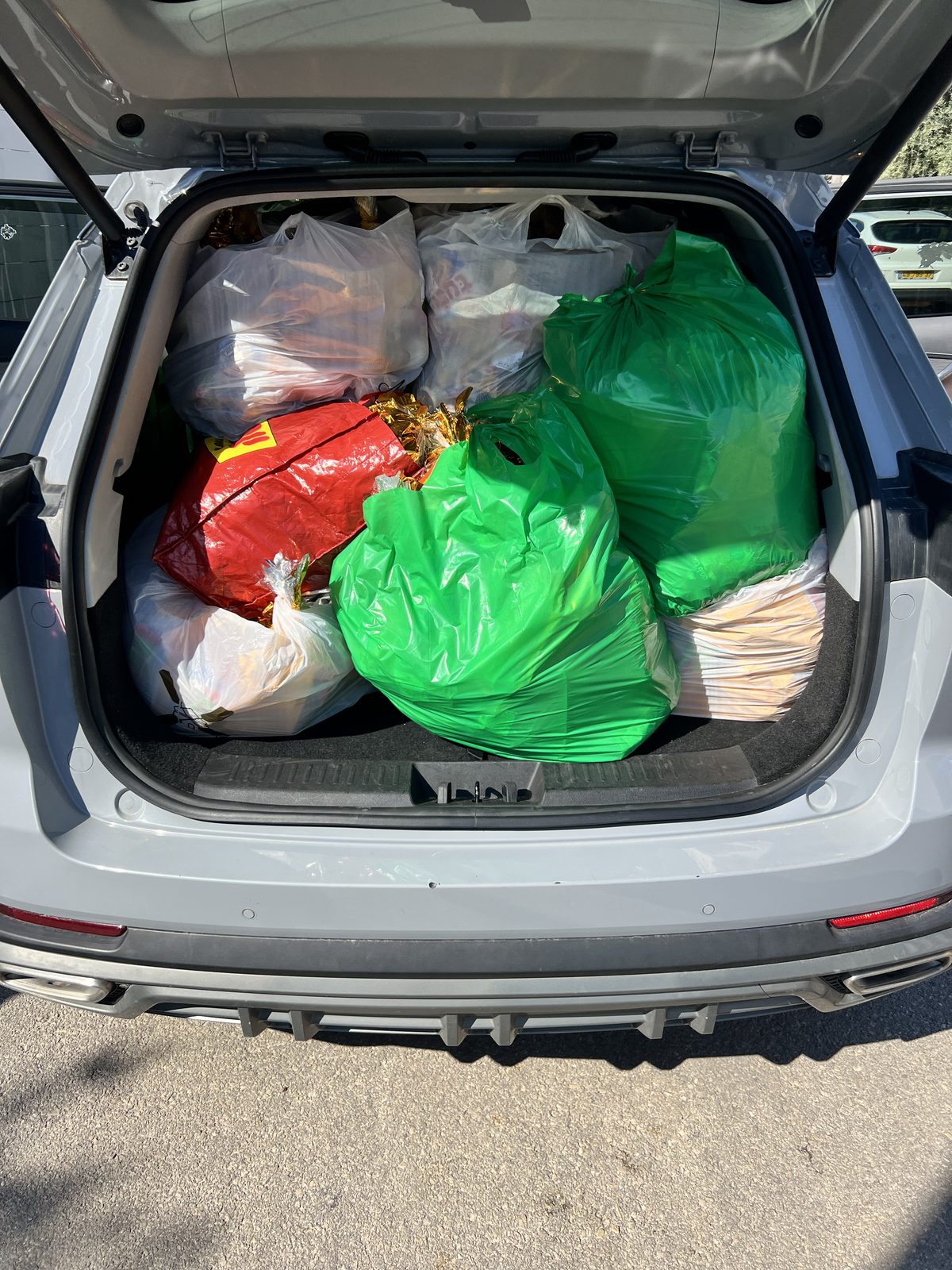 Coffre de voiture chargé de sacs de colis de Pourim prêts à être livrés