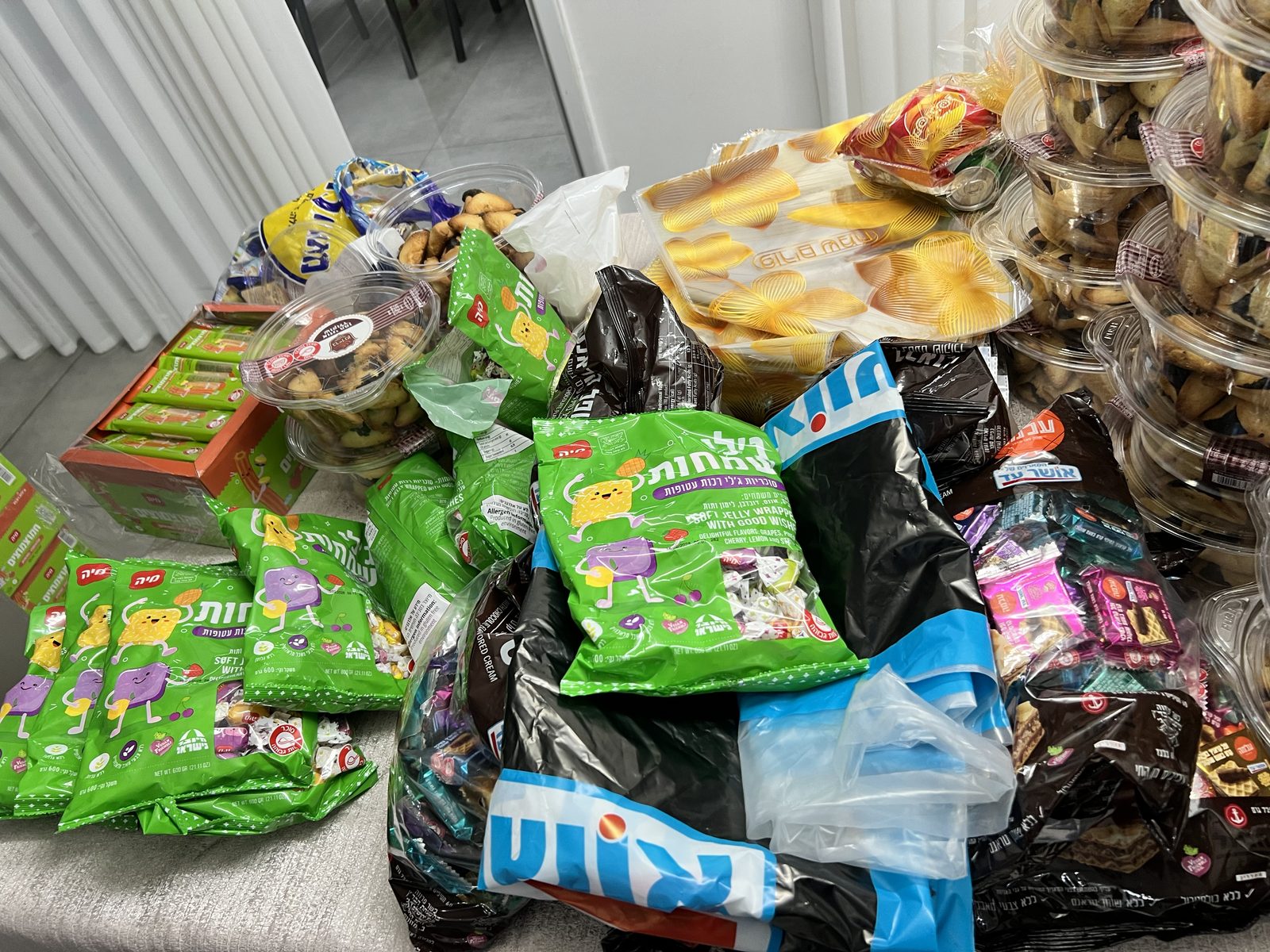 Table couverte de confiseries en cours d’empaquetage pour Pourim